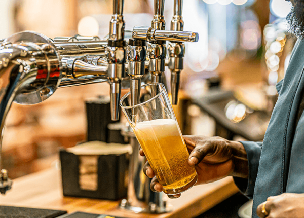 Photo of beer pint being poured at a pub.